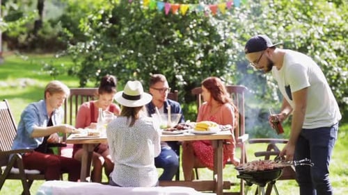 Friends Enjoying Backyard Barbecue on Sunny Day