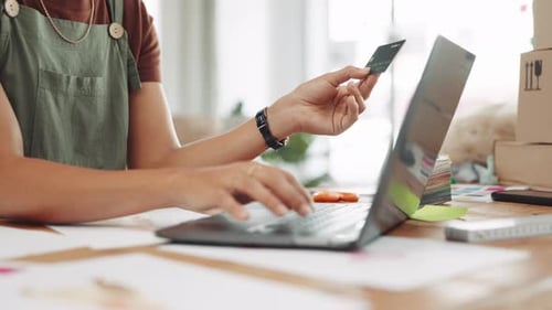 Person Using Laptop with Credit Card Indoors