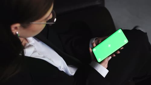 Close Up Woman Sitting at Home on the Couch with a Smartphone in Her Hands Mobile Phone Greenscreen