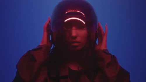 Woman Puts On Futuristic Black Helmet in Studio