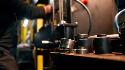 Close Up in a Service Station the Hands of an Auto Mechanic Work with Disk From a Car on a Press