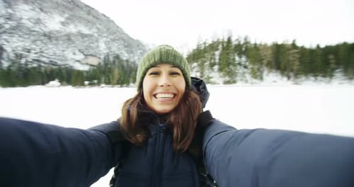 Cheerful Woman Hikes in Snowy Winter Wonderland