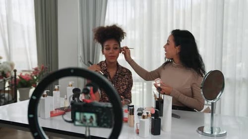 Dos mujeres influencers graban una transmisión en vivo de un vlog, una reseña de un vídeo, maquillaje, crucial