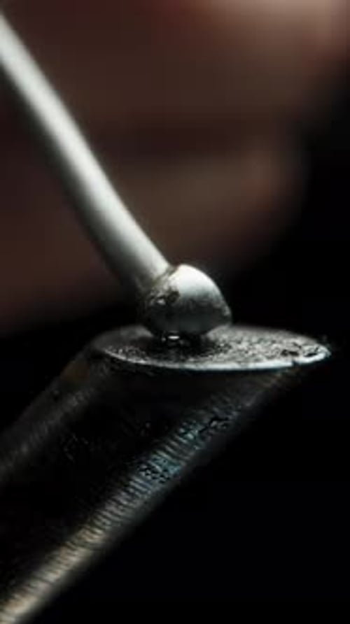 Vertical video. Solder Melting on the Overheated and Burned Soldering Iron Tip, Forming a Smooth