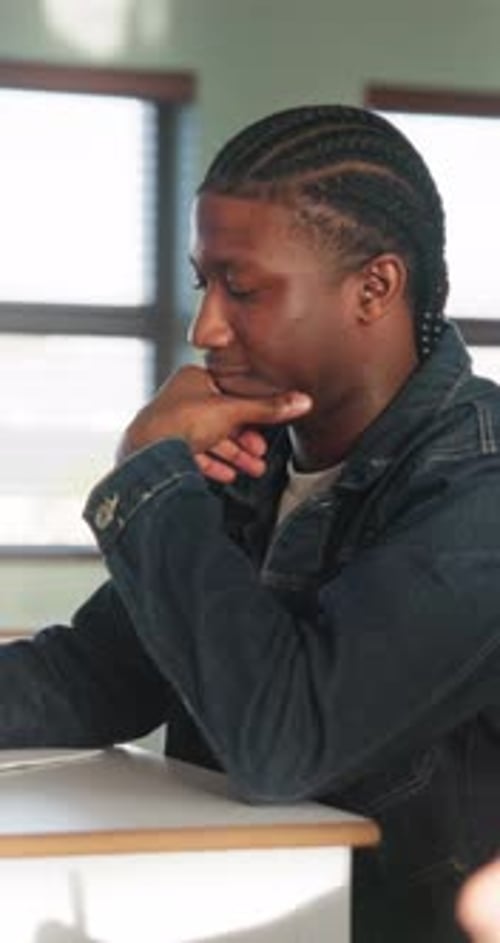 Listening, college and boy in classroom for notes, studying and learning in lesson at university