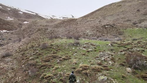 Lone Hiker Trekking Through a Rugged Mountain Landscape