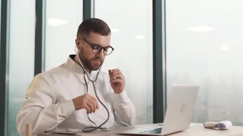 Bearded Man with Stethoscope Listening to Laptop