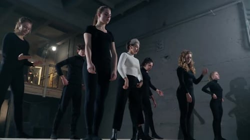 Elegant Dancers Perform Choreography in Gray Room