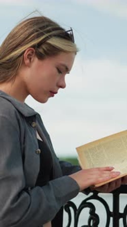 Woman Reads Book in City Park