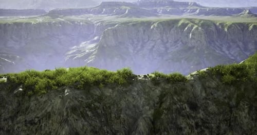 Camera Pan Over Grassy Cliff Edge Revealing Vast Canyon Landscape