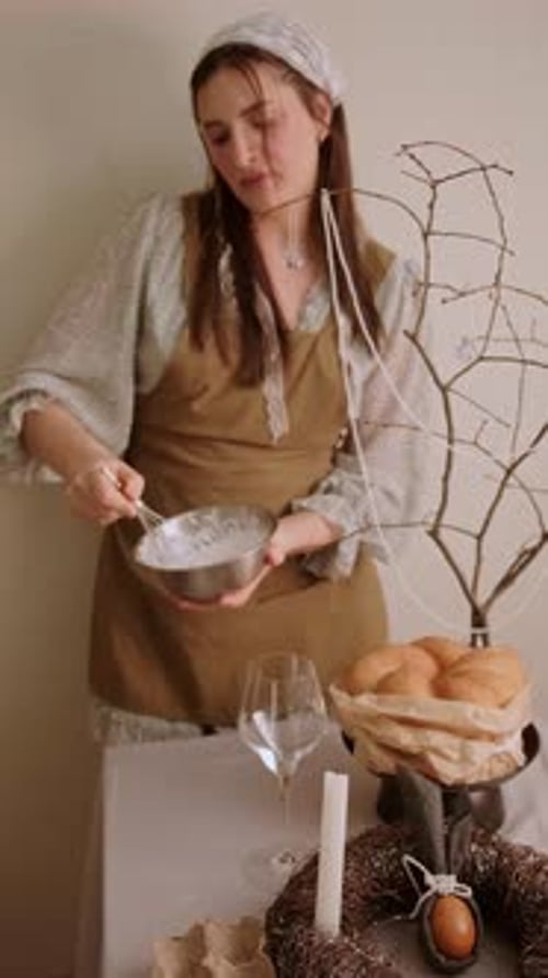 Ostervorfreude, Frau, die Schlagsahne für Osterkuchen auf einem festlichen Tisch in einer gemütlichen häuslichen Umgebung schlägt.
