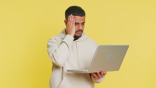 Young Man Gives Thumbs Down to Laptop Computer
