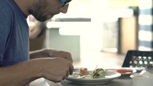 Young man enjoying a healthy scrambled egg breakfast in a city cafe