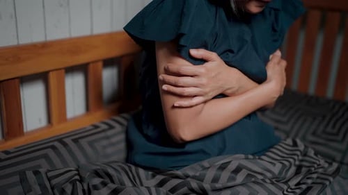 Gros plan d'une jeune femme en mauvaise santé qui a froid, qui est malade, qui éternue, qui a froid, qui tient une serviette, qui souffle sur