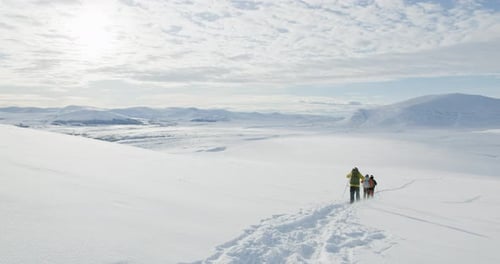 Hikers trekking through Snowy Winter Landscape