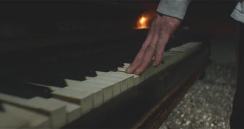 Close Up of Hand Playing Worn Piano Keys
