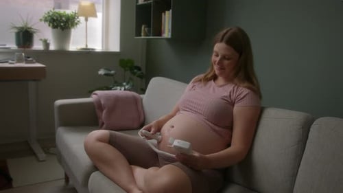 Femme enceinte assise en utilisant un doptone