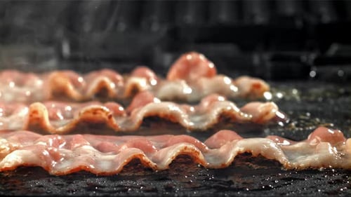 Close up of bacon frying