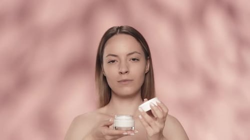 Cream for Skin Care A Young Halfnaked Woman Unscrews the Lid on a Jar of Cream and Inhales Its Aroma