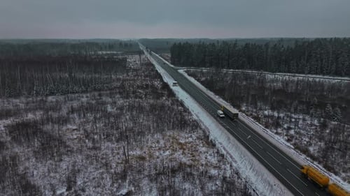 Cargo Freight Travels Past Winter Woods Large Truck Advances Through Icy Forested Roadside Area