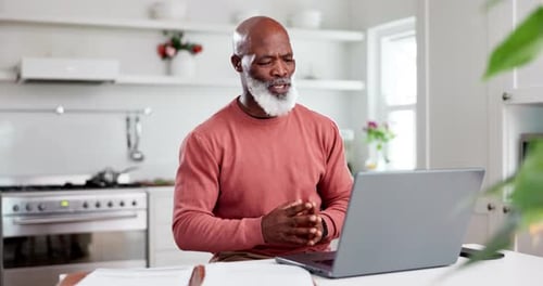 Mature Man Video Calling on Laptop in Kitchen