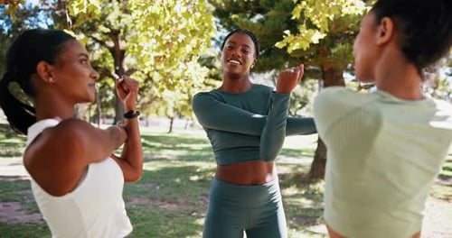 Friends Stretching Together in Urban Park on Sunny Day