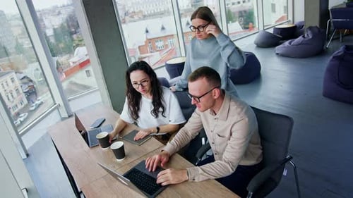 Comfortable spacious office with few people working in it.