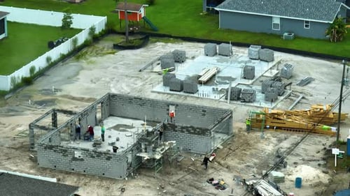 Travailleurs du bâtiment travaillant dans une nouvelle maison en construction à ossature inachevée d'une maison privée avec