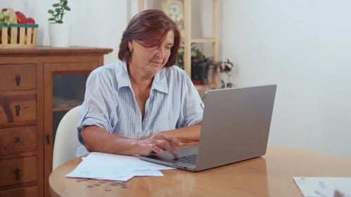 Woman Typing on Laptop at Table Indoors