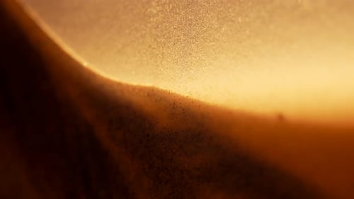 Sandy grains falling in slow motion. Abstract macro shot