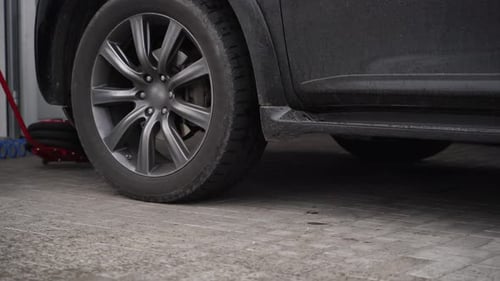 Mechanic Lifts Car with Red Air Jack Removes Tire Using Pneumatic Nut Runner in Garage Auto Repair