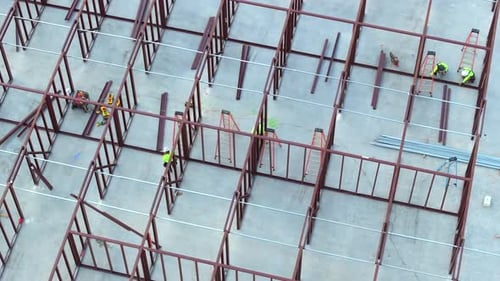 Arbeiter montieren ein Metallrahmengebäude auf einer Industriebaustelle in