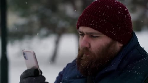 Slow Motion a Casual Young Guy Using Telephone in Winter When Snowing Snow Falling When Man