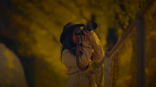 Woman with Camera Taking Photos at Night