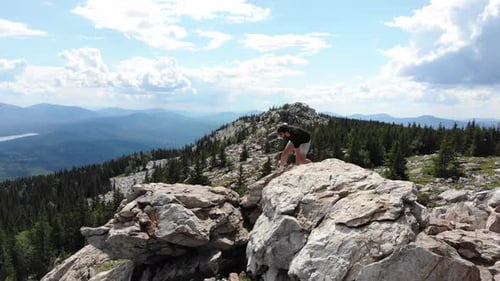 Man Runs Across Rocks on the Edge of a Mountain Cliff
