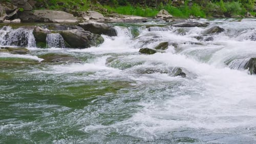 Stormy streams of water and cascades of mountain river waterfalls. Slow motion.