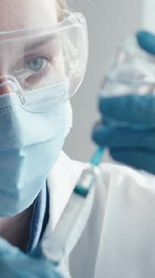 Medical Worker Filling Syringe with Vaccine in Lab