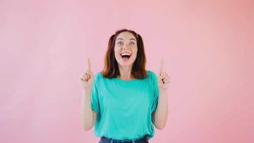 Excited Woman Smiling and Pointing Upward in Studio