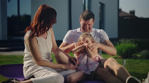 Happy Family Laughing Together in Backyard