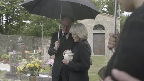 Family Gathering at Cemetery on a Rainy Day