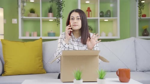 Woman Talking on Phone with Open Box in Living Room