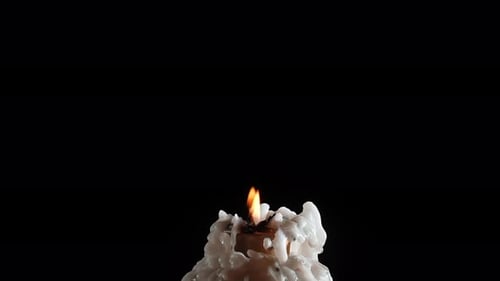 Melting Candle with Flame in Dark Background