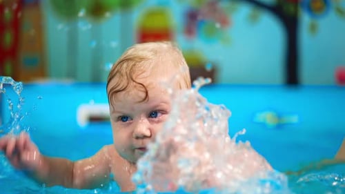 Chubby Caucasian baby is in the swimming pool.