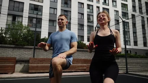 A Man and a Woman are Training Outside Sport Running on the Basketball Court