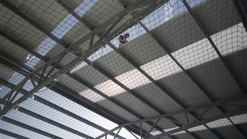 Arbeiter montieren Paneele beim Bau des Daches eines Industriegebäudes