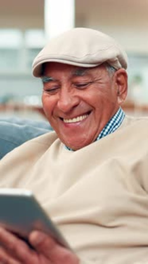 Smiling Senior Man Using Tablet Indoors at Home