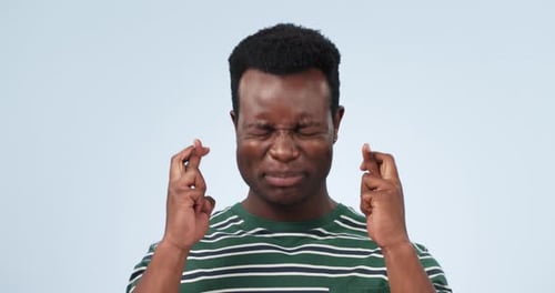Hope, fingers crossed and black man in studio with anxiety for feedback