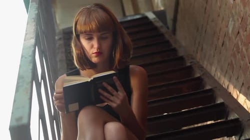 Woman Reading Book on Urban Outdoor Staircase