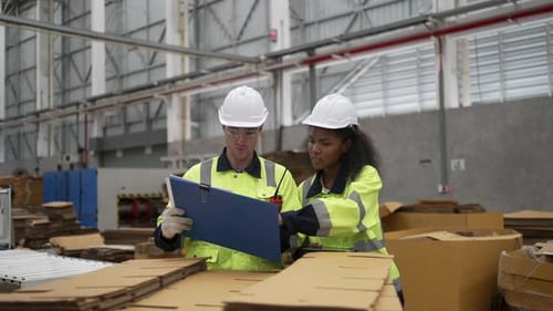 Factory Team Using Digital Tablet Among Cardboard Boxes