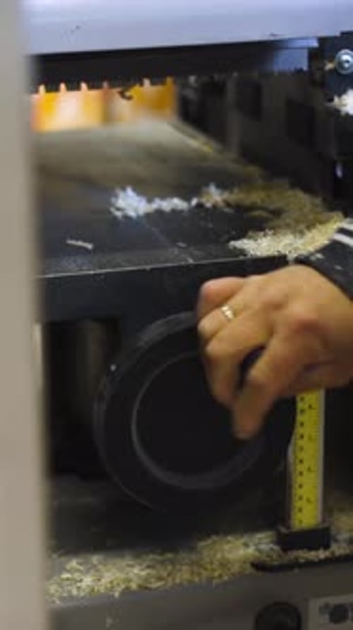 Man Adjusting Woodworking Machine in Workshop